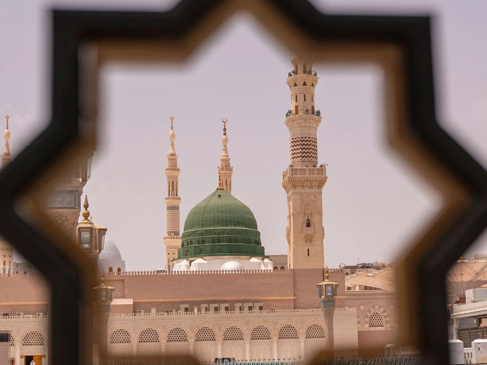 Green Dome of Masjid an-Nabawi, Madinah, seen through a star-shaped lattice
